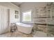 Bright bathroom featuring a soaking tub, tiled shower, and natural light from a window at 10865 Glenhurst Pass, Duluth, GA 30097