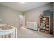 Well-lit Bedroom with a crib, changing table, and open door at 10865 Glenhurst Pass, Duluth, GA 30097