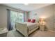 Cozy bedroom with a large window, neutral carpet, and a comfortable bed at 10865 Glenhurst Pass, Duluth, GA 30097