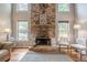 Bright living area featuring a stone fireplace, neutral walls, and a cozy seating area at 10865 Glenhurst Pass, Duluth, GA 30097