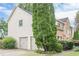 Side view featuring well-maintained landscaping and a two-car garage at 10865 Glenhurst Pass, Duluth, GA 30097