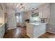 Well-lit kitchen featuring light cabinets, stone countertops, hardwood floors and stainless steel appliances at 10865 Glenhurst Pass, Duluth, GA 30097