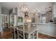 Open kitchen and dining area featuring white cabinets, stainless appliances, and modern decor at 10865 Glenhurst Pass, Duluth, GA 30097