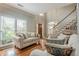 Bright and airy living room with hardwood floors, large windows, and stylish staircase to the upper level at 10865 Glenhurst Pass, Duluth, GA 30097