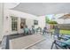 Back patio features stone flooring, shade and a seating area; creating an inviting outdoor space at 10865 Glenhurst Pass, Duluth, GA 30097