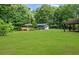 Expansive backyard view showing the large lawn and wooden deck of the house, surrounded by lush trees at 30 Roseberry Dr, Stockbridge, GA 30281