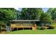 Backyard with a home featuring a wooden deck, stairs, and plenty of green space surrounded by mature trees at 30 Roseberry Dr, Stockbridge, GA 30281