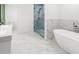 Contemporary bathroom featuring marble tile, a glass enclosed shower and standalone tub at 30 Roseberry Dr, Stockbridge, GA 30281