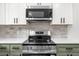 Modern stainless steel stove and microwave with white and colored cabinets at 30 Roseberry Dr, Stockbridge, GA 30281