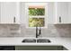 Close-up of a modern kitchen sink and white cabinets under a window at 30 Roseberry Dr, Stockbridge, GA 30281