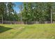 Expansive backyard with lush greenery and tall wooden fence, offering serene outdoor living at 3796 Village Crossing Ln, Ellenwood, GA 30294