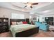 Large bedroom featuring a tray ceiling, ceiling fan and relaxing seating area at 3796 Village Crossing Ln, Ellenwood, GA 30294
