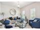 Bright and cozy living room featuring comfortable seating, a decorative mirror, and natural light at 3796 Village Crossing Ln, Ellenwood, GA 30294