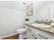 Elegant half bathroom with granite countertop, decorative mirror, and wood look flooring at 260 Westview Sw Pl, Atlanta, GA 30314