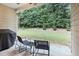 View of outdoor patio with chairs, small table, grill, and fenced-in backyard with lots of trees at 263 Jefferson Ave, Canton, GA 30114