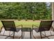 View of outdoor patio with chairs, small table, and fenced-in backyard with lots of trees at 263 Jefferson Ave, Canton, GA 30114