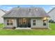 Back exterior of home with a patio, grill, and seating, with a large grassy fenced-in backyard at 263 Jefferson Ave, Canton, GA 30114