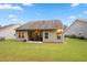 Back exterior of home with a patio, grill, and seating, with a large grassy fenced-in backyard at 263 Jefferson Ave, Canton, GA 30114