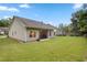 Back exterior of home with a patio, grill, and seating, with a large grassy fenced-in backyard at 263 Jefferson Ave, Canton, GA 30114