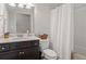 Bathroom featuring a dark vanity, toilet, shower with curtain, and neutral walls at 263 Jefferson Ave, Canton, GA 30114