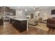 Open kitchen with dark cabinets, granite countertops, and a large island adjacent to the living room area at 263 Jefferson Ave, Canton, GA 30114