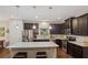 A spacious kitchen featuring dark wood cabinets, a stainless steel refrigerator, and a large center island with pendant lighting at 263 Jefferson Ave, Canton, GA 30114