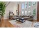 Bright living room features soaring windows, hardwood floors and a comfortable sectional sofa at 2832 Springbluff Ln, Buford, GA 30519