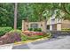 Sign at The Terraces-At Peachtree community entrance features lush greenery and a manicured lawn at 1 Biscayne Nw Dr # 112, Atlanta, GA 30309
