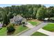 Aerial view of a well-manicured grey brick home with mature trees, green lawn and long driveway at 1254 Hadaway Garden Nw Dr, Kennesaw, GA 30152