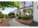 Inviting front porch with chairs, manicured landscaping and grey brick exterior at 1254 Hadaway Garden Nw Dr, Kennesaw, GA 30152