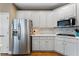 Well-lit kitchen featuring white cabinets, stainless steel appliances, and hardwood floors at 1254 Hadaway Garden Nw Dr, Kennesaw, GA 30152