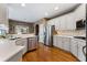 Modern kitchen with stainless steel appliances, white cabinets, and hardwood flooring at 1254 Hadaway Garden Nw Dr, Kennesaw, GA 30152