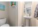 Cozy half bathroom with a pedestal sink, toilet, and nautical-themed artwork at 3350 Clawing Hawk Way, Douglasville, GA 30135