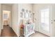 Bright entryway featuring a decorated cabinet, white door with decorative glass, and a view into the half bathroom at 3350 Clawing Hawk Way, Douglasville, GA 30135