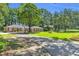 Expansive front yard with mature trees, brick home, and basketball hoop on driveway at 400 Little John Nw Dr, Lilburn, GA 30047