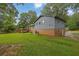 View of the back of the house, with a brick foundation and a spacious lawn at 1031 Washington Ave, Woodstock, GA 30188