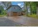 Two-story home with a gray exterior, brick accents, attached garage, long driveway, and newly landscaped features at 1031 Washington Ave, Woodstock, GA 30188