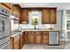 Well-lit kitchen with wood cabinets, granite countertops, stainless steel appliances and backyard views at 1031 Washington Ave, Woodstock, GA 30188