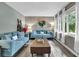 Bright living room with comfortable blue sofas, a decorative painting, hardwood floors, and ample natural light at 1031 Washington Ave, Woodstock, GA 30188