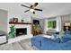 Bright living room featuring a brick fireplace, wood mantle, and stylish blue sofa at 1031 Washington Ave, Woodstock, GA 30188