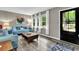 Cozy living room with modern decor, hardwood floors, large windows, and comfortable seating arrangement at 1031 Washington Ave, Woodstock, GA 30188