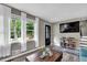 Cozy living room with modern decor, hardwood floors, three windows, and comfortable seating arrangement at 1031 Washington Ave, Woodstock, GA 30188