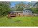 Backyard view of the two-story home with a deck, well-maintained lawn, brick accents, and an RV at 1031 Washington Ave, Woodstock, GA 30188