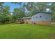 Backyard of the two-story home featuring a deck, well-maintained lawn, brick accents, and an RV at 1031 Washington Ave, Woodstock, GA 30188