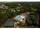 An aerial view of a neighborhood with a pool, tennis court, water slide, and mature trees at 11255 Knollwood Bnd, Johns Creek, GA 30097