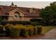 Exterior view of a beige building with a brown roof and a manicured lawn with trimmed bushes at 11255 Knollwood Bnd, Johns Creek, GA 30097