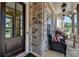 Elegant front entrance with brick accents, a dark wood door, and a welcoming porch setting at 11255 Knollwood Bnd, Johns Creek, GA 30097