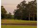 A beautiful fairway with a golf cart on the green surrounded by mature hardwood trees at 11255 Knollwood Bnd, Johns Creek, GA 30097