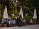 Outdoor dining area with tables, chairs, umbrellas, and people at 11255 Knollwood Bnd, Johns Creek, GA 30097