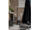 Outdoor patio area featuring tables, chairs, an umbrella, and a brick wall with decorative elements at 11255 Knollwood Bnd, Johns Creek, GA 30097
